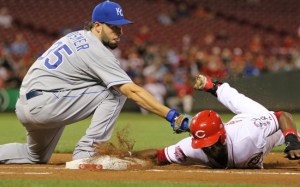 Cincinnati Reds' Jason Bourgeois (30) dives safely back to first base as Kansas City Royals first baseman Eric Hosmer (35) applies the tag on a pick-off attempt during the third inning of a baseball game, Wednesday, Aug. 19, 2015, in Cincinnati. (AP Photo/Gary Landers)