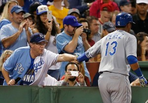 Kansas City Royals' Salvador Perez (13) celebrates his three-run home run with a fan during the sixth inning of a baseball game against the Boston Red Sox in Boston, Saturday, Aug. 22, 2015. (AP Photo/Michael Dwyer)