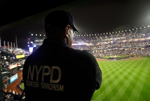 New York Police Department Counter Terrorism Agent Sgt. Kevin Mikowski watches from a camera platform during a 9/11 remembrance ceremony before the New York Mets baseball game against the Chicago Cubs at Citi Field, Sunday, Sept. 11, 2011, in New York. (AP Photo/Kathy Willens)